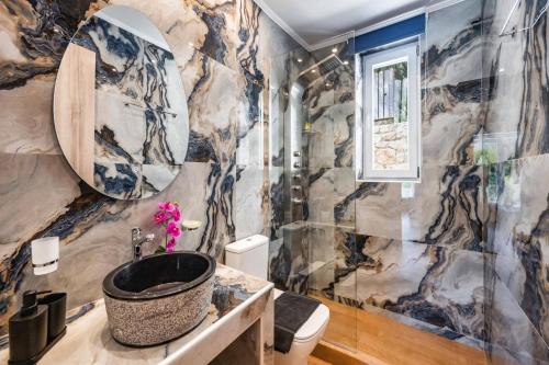 a bathroom with a marble wall at Villa Mario by Villa Plus in Katokhórion