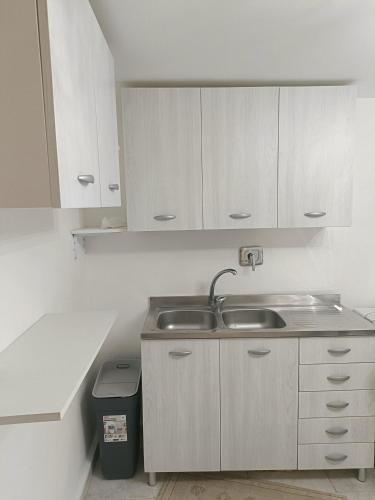 a kitchen with white cabinets and a sink at La terrazza sul fiume in Spoleto