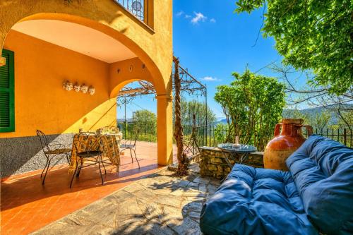 an outdoor patio with a couch and a table at Villa I Tre Archi for 6 with Private Garden - Happy Rentals in Pisano