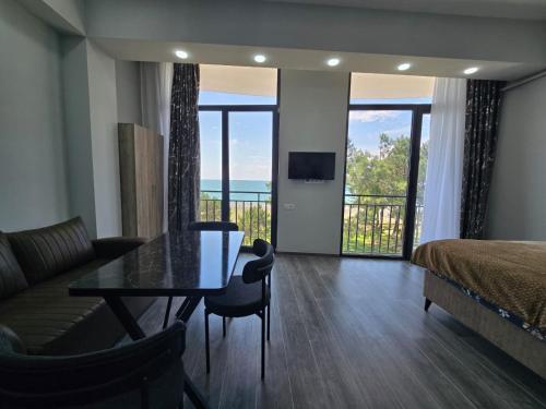 a living room with a bed and a table and a couch at Welcome3 in Achʼqva