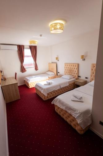 a hotel room with three beds and a window at Prenoćište BIS in Prijepolje
