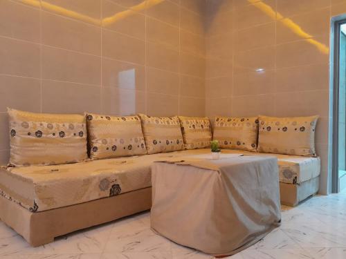 a couch with pillows and a table in a room at Relax House 2 in Al Massira Airport