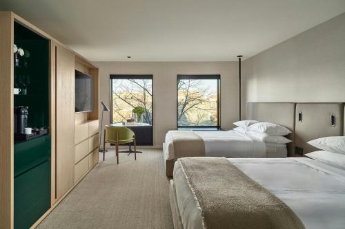 a hotel room with two beds and a television at The Satire, Autograph Collection in Alexandria