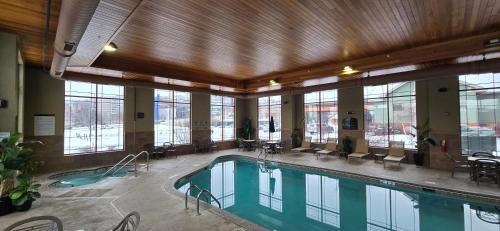 a large swimming pool in a building with windows at Canal Park Lodge in Duluth