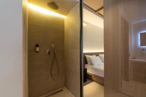 a bathroom with a shower and a bed in a room at La Finestra in Nydri