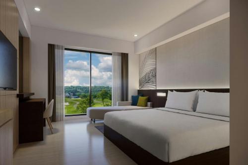 a hotel room with a bed and a large window at Courtyard by Marriott Manado in Manado