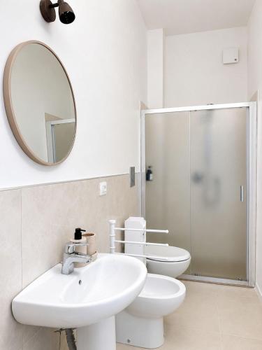 a bathroom with a sink and a toilet and a mirror at Marechiaro apartment in Monopoli