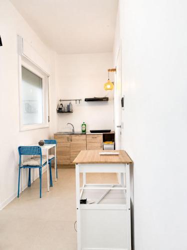 a white kitchen with a counter and a table at Marechiaro apartment in Monopoli