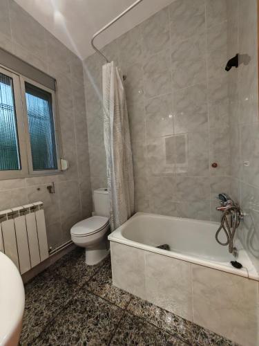 a bathroom with a toilet and a tub and a sink at Casa Chorreón in Letur