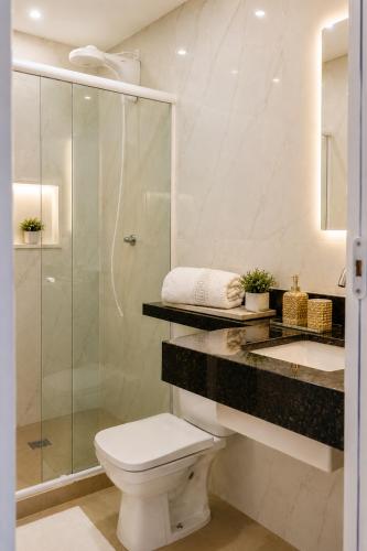 a bathroom with a shower and a toilet and a sink at Pousada Recanto do Chef in Búzios