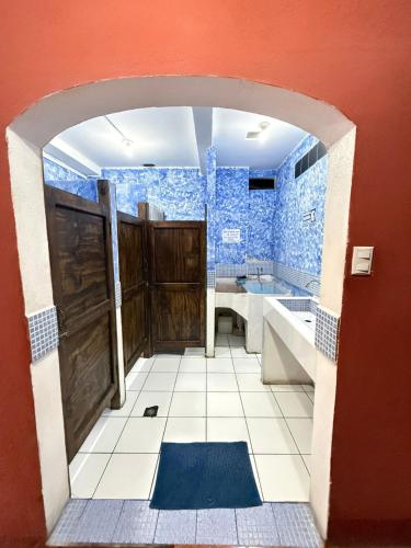 a bathroom with a shower and a sink and a door at Cristales de Antigua La Calzada in Antigua Guatemala