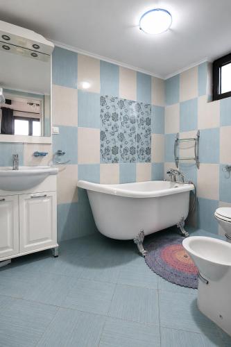 a bathroom with a tub and a sink and a toilet at Villa Bellevue Amazing Sea View 7 Guests in Krašići