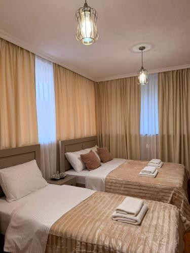 two beds in a hotel room with towels on them at Horizont Boutique Hotel in Telavi