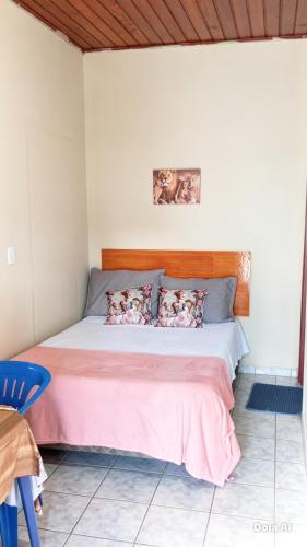 a bedroom with a bed with a pink blanket at República Nunes e Silva in Vilhena
