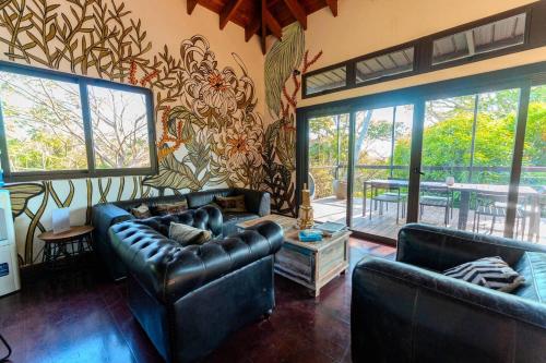 a living room with two leather couches and a table at Villa Noelia by Embera Collection in Saboga