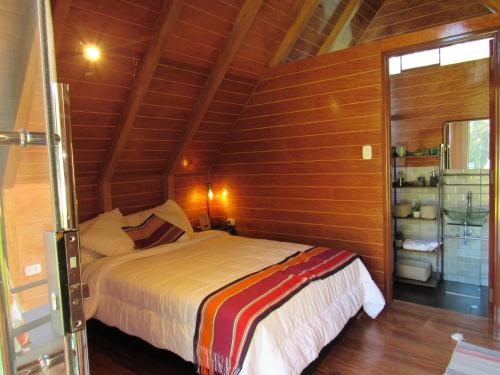 a bedroom with a bed in a room with wooden walls at Edén del Aliso in Santa Barbara
