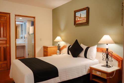 a bedroom with a large bed and a bathroom at Hotel la Parroquia in Pátzcuaro