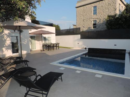 a patio with chairs and a swimming pool at Villa RoseMary in Split