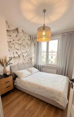 a bedroom with a white bed and a window at Apartament Grochowa in Białystok