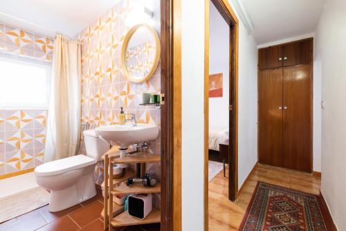 a bathroom with a sink and a toilet and a mirror at Alpujarra Relax with Terrace in Órgiva