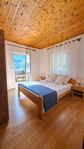 a bedroom with a large bed with a wooden ceiling at Lorena Rooms in Risan