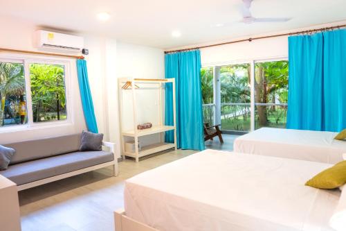 a bedroom with two beds and a couch at Blue Mango Beach Hotel in Guachaca