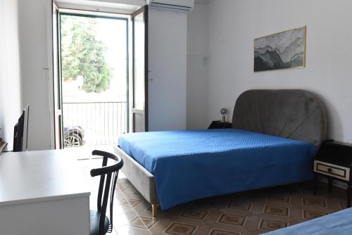 a bedroom with a blue bed and a large window at Harit16 in Lecce