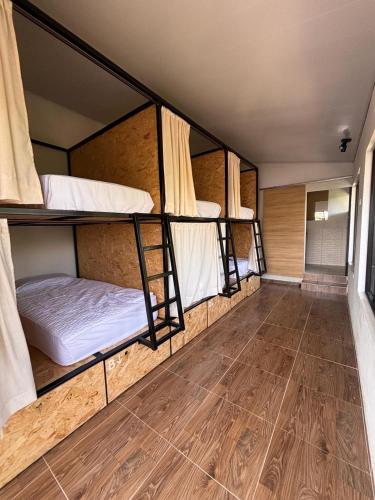 a room with three bunk beds and a wooden floor at Solarte Hostel in Vergara
