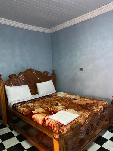 a bedroom with a wooden bed with two pillows at Guest house in Hārer