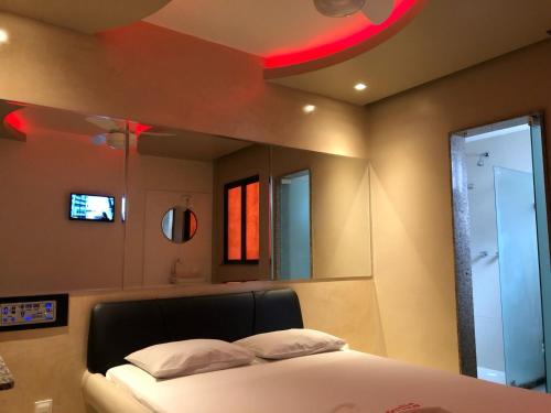 a bedroom with a bed and a large mirror at Hotel Alfama Motel in Salvador