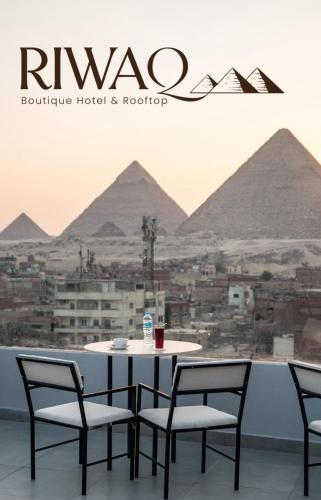 a table and chairs with a view of the pyramids at Riwaq Pyramids View Inn & Rooftop in Cairo