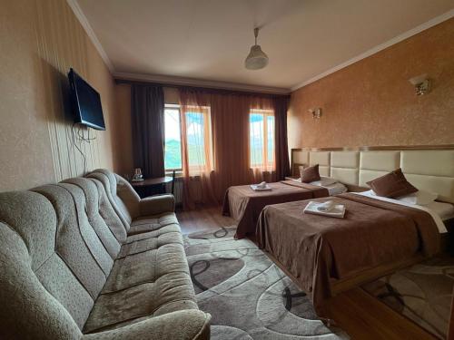 a hotel room with two beds and a couch at AVAGYAN'S Hotel-restaurant in Goris