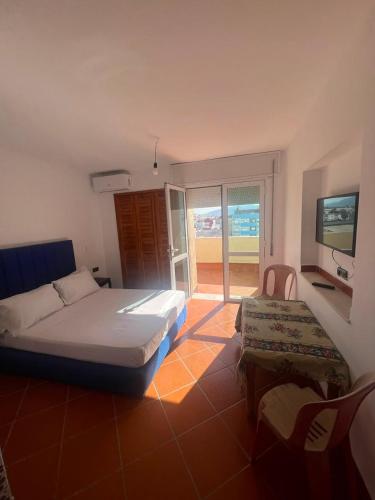 a bedroom with a bed and a television and a chair at Residence Jamal Only Family in Martil