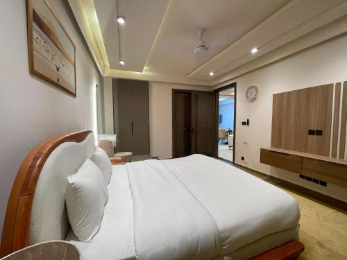 a bedroom with a large white bed in a room at Designer Boutique Hotel Serviced Apartments Bahria Town Islamabad & Rawalpindi - LMY in Rawalpindi