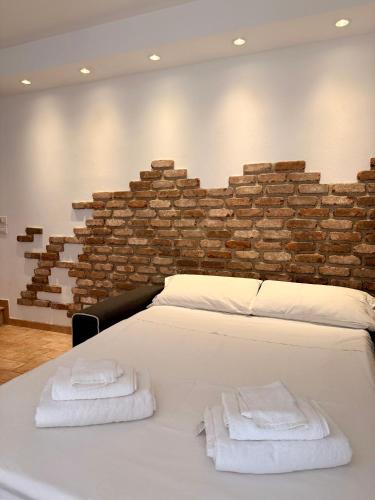 a bedroom with a white bed with towels on it at Corte Magnolia Terme & Lago di Garda in Colà di Lazise