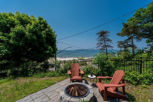 a patio with two chairs and a fire pit at Waterfront Cottage w Pool Beach Access in Fort Erie