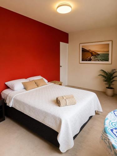a bedroom with a large bed with a red wall at Paracas Desert Lodge&Tours in Paracas