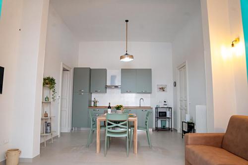 a living room with a table and a kitchen at Dimora Noè e Concettina in Botrugno