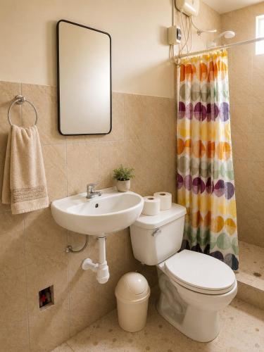 a bathroom with a sink and a toilet and a mirror at Paracas Desert Lodge&Tours in Paracas