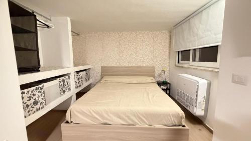 a small bedroom with a bed and a tv at Rosu in Triggiano
