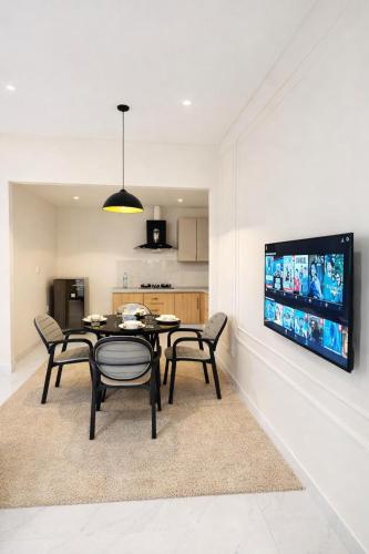 a dining room with a table and chairs and a tv at Second Stay apartments in Faisalabad