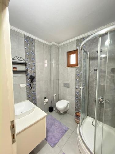 a bathroom with a shower and a toilet and a sink at My White Residence in Trabzon