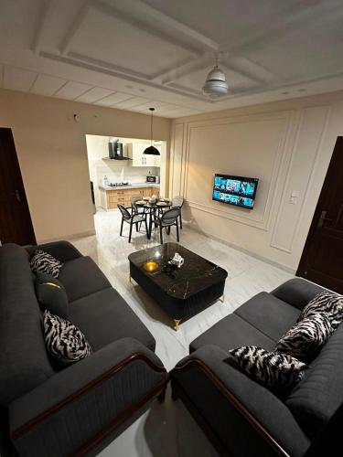 a living room with two couches and a table at Second Stay apartments in Faisalabad