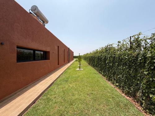 a row of trees next to a brick building at Villa 74 Serenety in Heddad