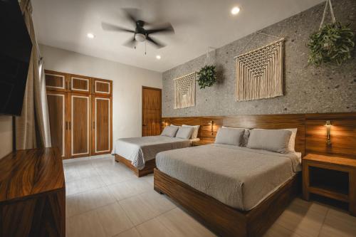 a bedroom with two beds and a ceiling fan at Suite Premium con piscina privada en Valladolid - Penca Leonor 12 in Valladolid