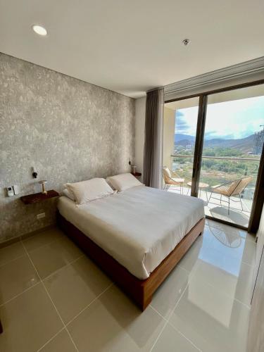 a bedroom with a large bed and a large window at Ola del Mar in Gaira
