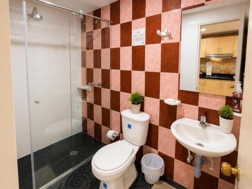 a bathroom with a toilet and a sink at Hospedaje Edificio Alejandria in Sogamoso