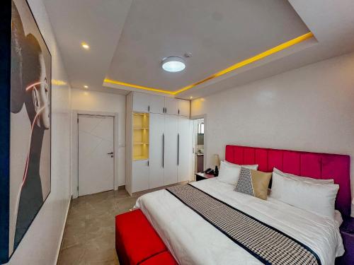 a bedroom with a large bed with a red headboard at Kiara Apartments in Kigali