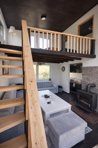 a living room with a stairs leading up to a loft at Kućica Sreće in Visoko
