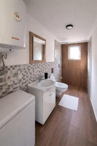 a bathroom with a white sink and a toilet at Kućica Sreće in Visoko